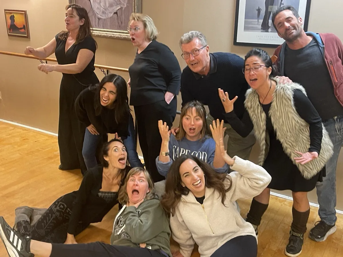 Workshop participants making wild, joyful expressions together