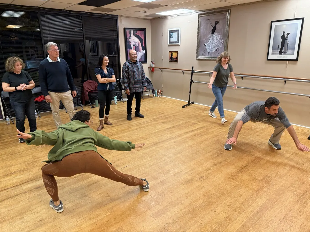 Workshop participants in mid-play, lunging and moving together with energy